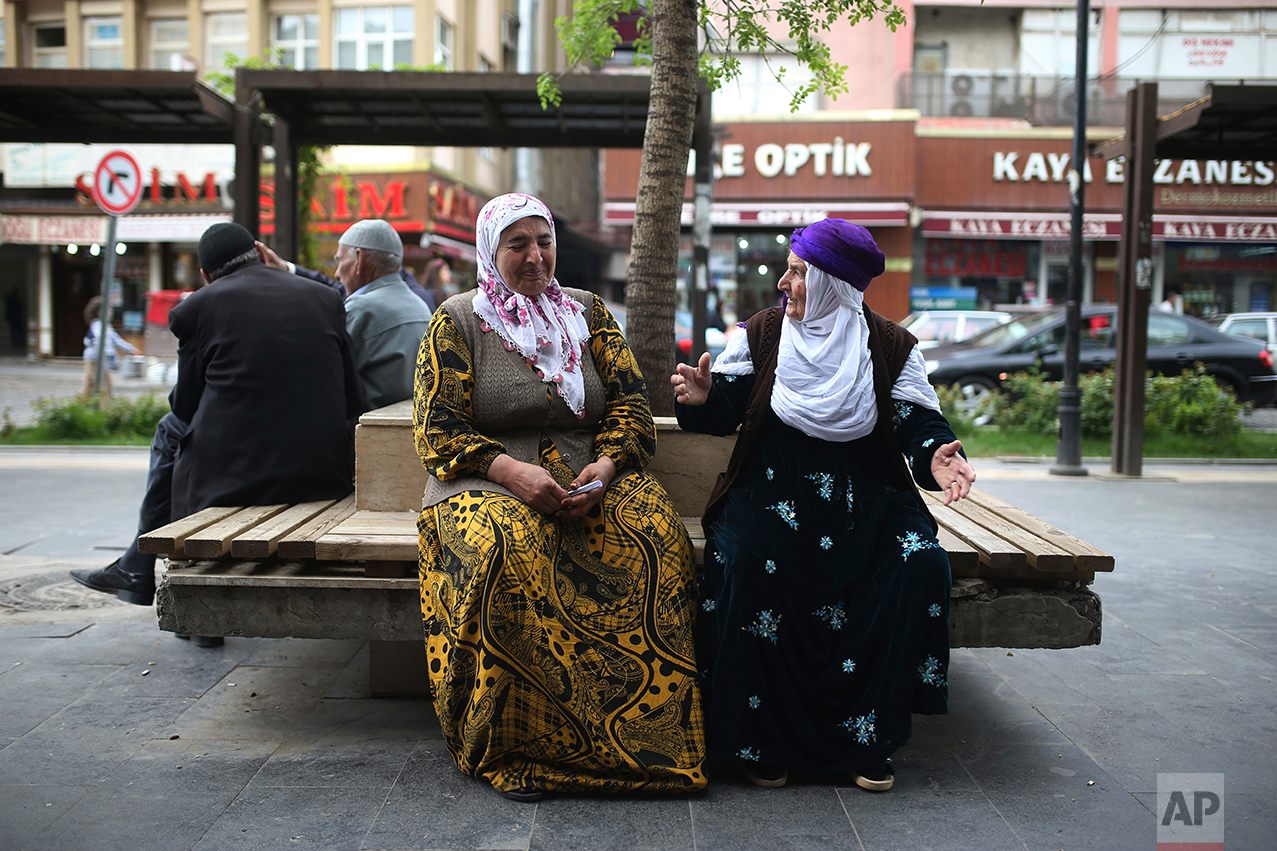 Two women chat as they sit in a boulevard in Diyarbakir, Turkey, Monday, April 17, 2017. Turkey's main opposition party urged the country's electoral board Monday to cancel the results of a landmark referendum that granted sweeping new powers to the nation's president, citing what it called substantial voting irregularities. (AP Photo/Emre Tazegul)