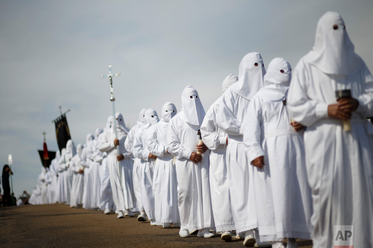 In this Friday, April 14, 2017 photo, penitents from the 'El Santo Entierro' brotherhood take part in a procession in the small village of Bercianos de Aliste, northwestern Spain. For days leading up to Easter Sunday each year, hundreds of colorful processions featuring penitents and magnificently decorated religious floats parade through villages and cities across the country, celebrating the Passion of Christ from the crucifixion to resurrection, celebrations which have become a major tourist attraction and televised nationwide. (AP Photo/Daniel Ochoa de Olza)