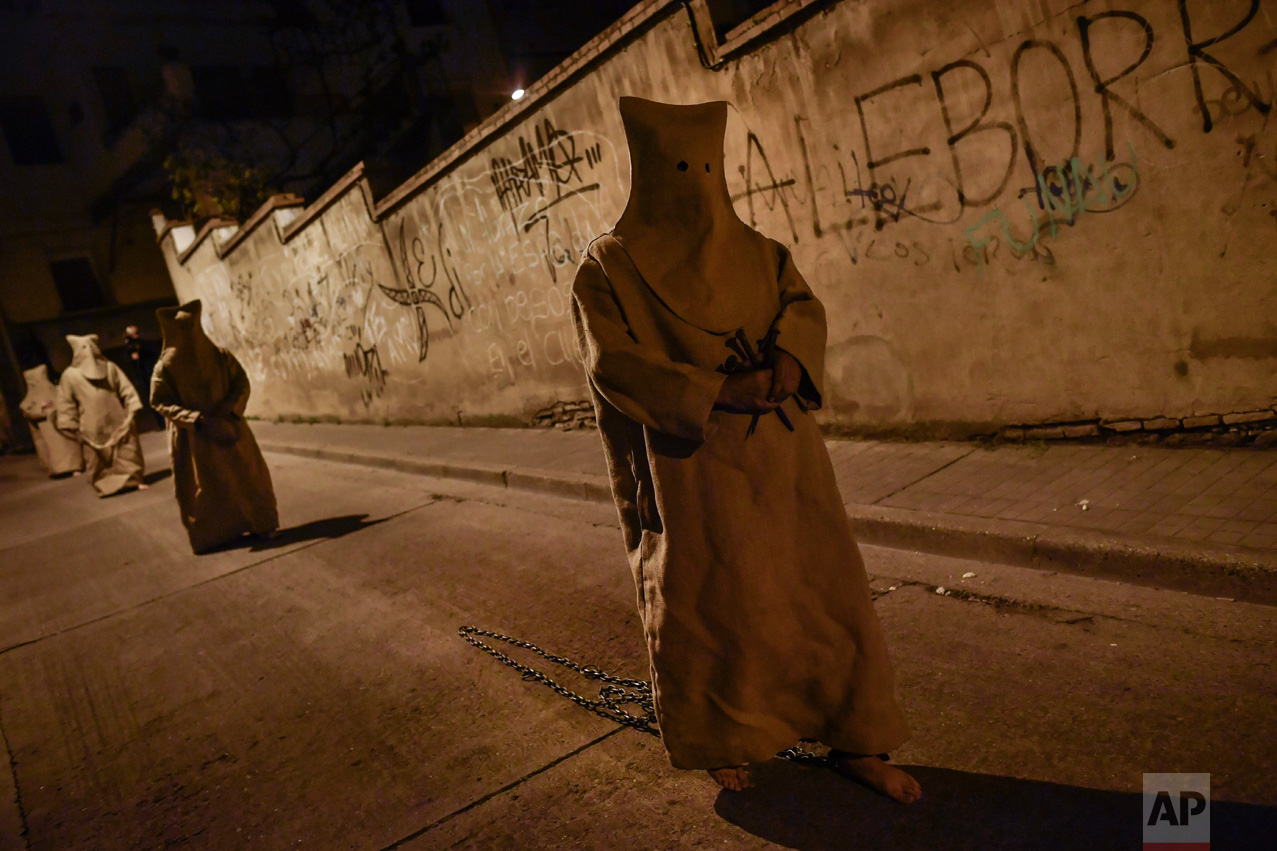In this Tuesday, April 11, 2017 photo, 'Ensacados'' or masked penitents take part in the procession of the "Silencio del Santisimo Cristo del Rebate" brotherhood, during Holy Week in Tarazona, northern Spain. (AP Photo/Alvaro Barrientos)