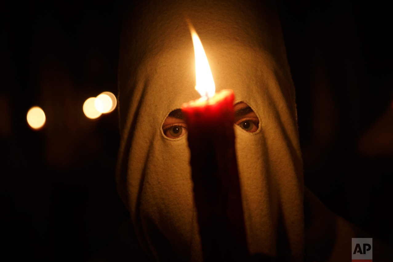 In this Friday, April 14, 2017 photo, penitents from the "Hermandad Penitencial de Jesus Yacente" brotherhood take part in a procession in Zamora, Spain. (AP Photo/Daniel Ochoa de Olza)