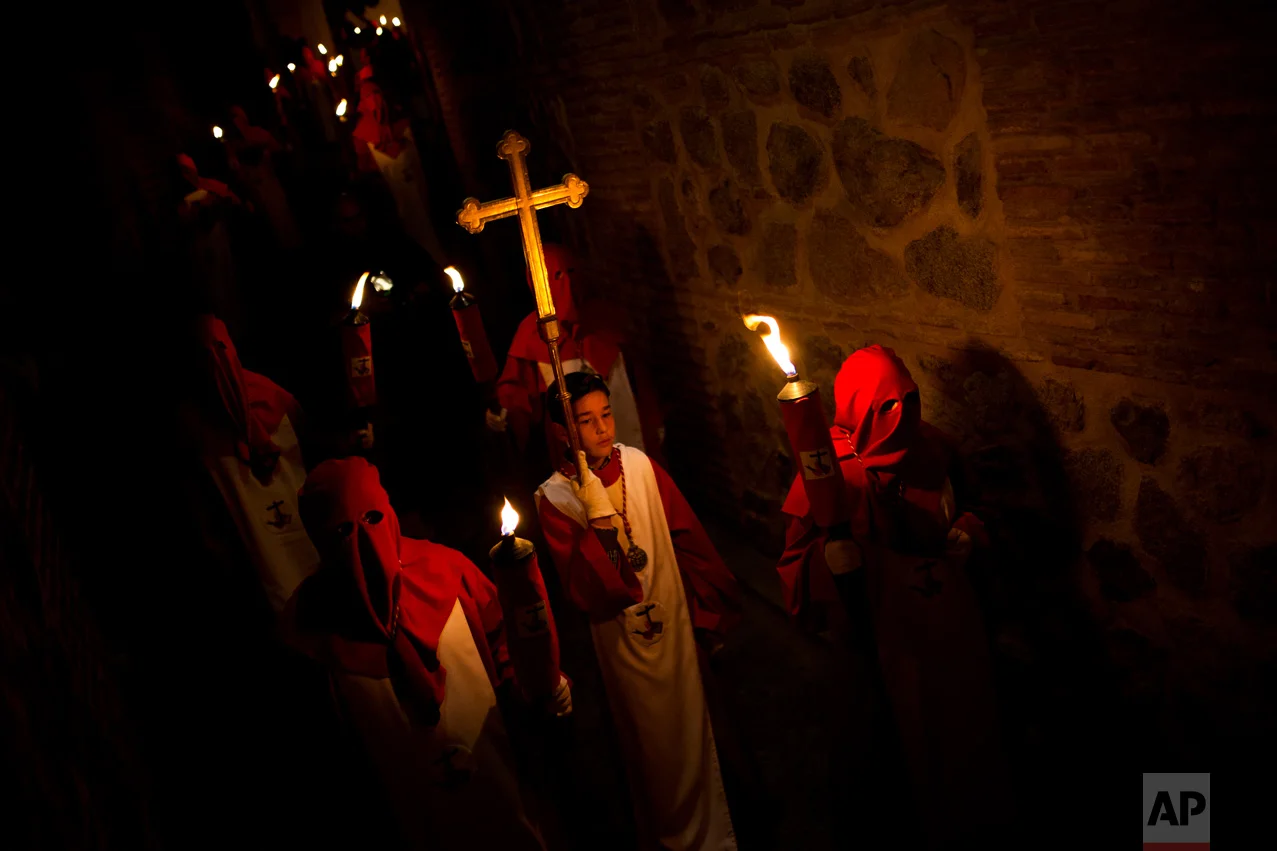 EDS NOTE : SPANISH LAW REQUIRES THAT THE FACES OF MINORS ARE MASKED IN PUBLICATIONS WITHIN SPAIN. In this Tuesday, April 11, 2017 photo, hooded penitents from "Cristo de los Angeles" brotherhood take part in a traditional annual Holy Week procession in Toledo, Spain. (AP Photo/Francisco Seco)