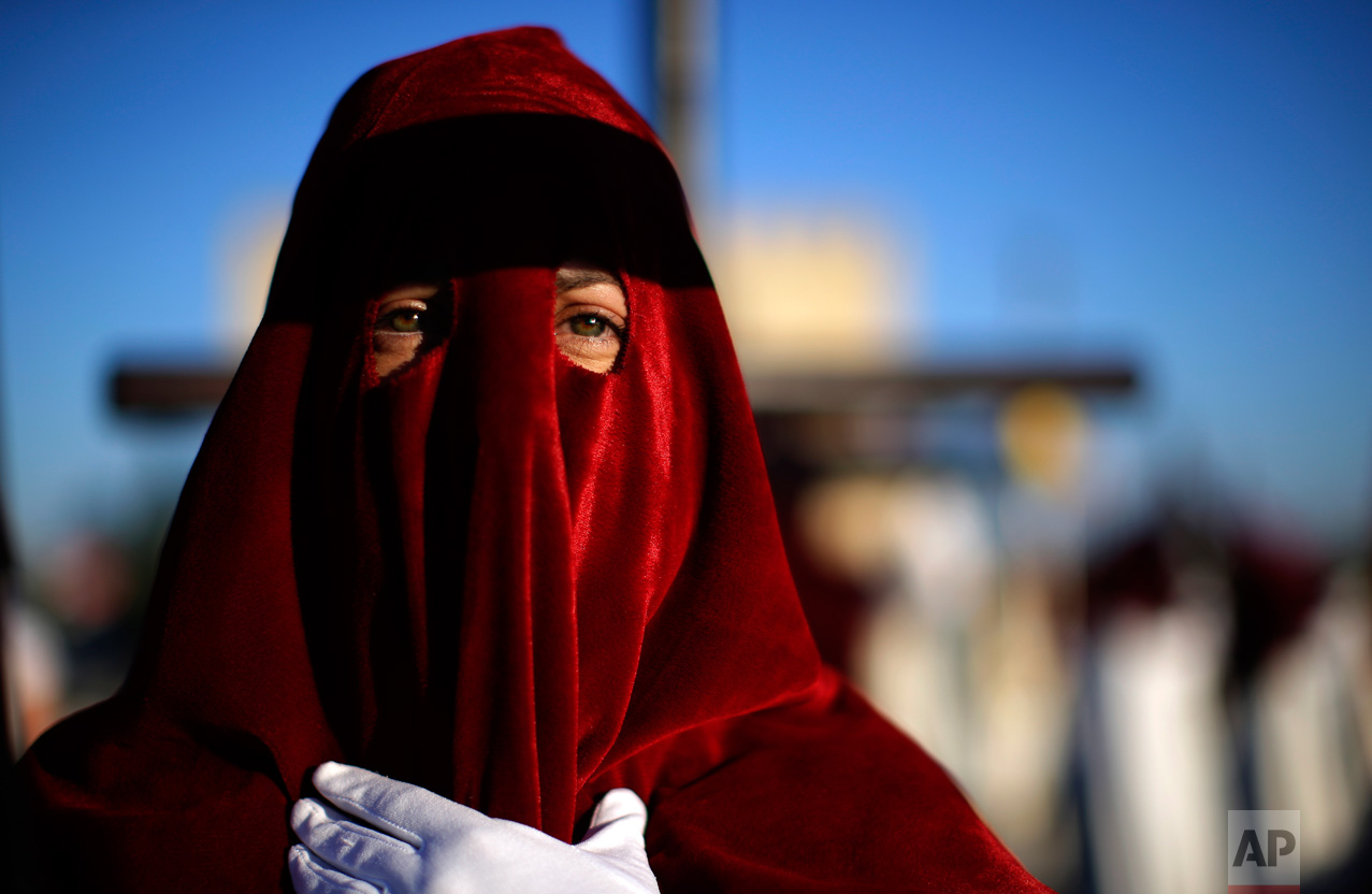In this Monday, April 10, 2017 photo, a hooded penitent from "Vera Cruz" brotherhood takes part during a Holy Week procession in Cordoba, Spain. (AP Photo/Manu Fernandez)