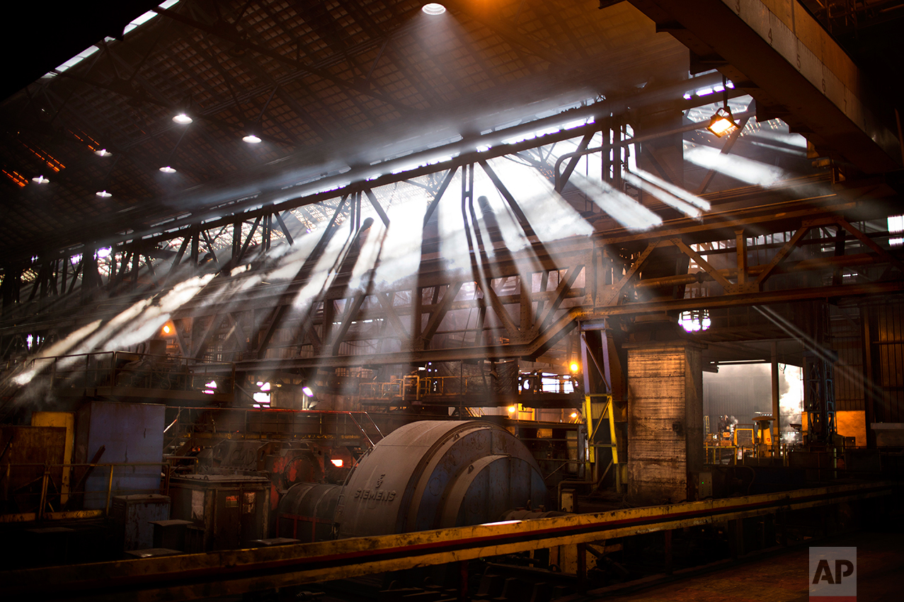 In this Friday April 7, 2017 photo, sunlight streams into a "British Steel" factory during steel production at Hayange, a commune in the Moselle department in Grand Est in north-eastern France. In eastern France’s industrial rustbelt, workers are massing behind the virulently nationalistic politics of populist Marine Le Pen. A large chunk of them will come from once left-leaning industrial towns like Hayange, scarred by the closure of its blast furnaces. (AP Photo/Emilio Morenatti)