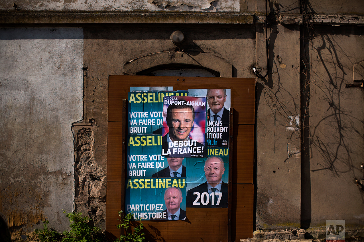 In this Tuesday April 4, 2017 photo, a poster showing a portrait of an independent candidate for the 2017 French Presidential election Nicolas Dupont Aignan is pasted next to others showing François Asselineau, candidate of the UPR party (Union populaire républicaine ie Popular Republican Union) on a wall of a former factory on the outskirts of Hayange. In eastern France’s industrial rustbelt, workers are massing behind the virulently nationalistic politics of populist Marine Le Pen. A large chunk of them will come from once left-leaning industrial towns like Hayange, scarred by the closure of its blast furnaces. (AP Photo/Emilio Morenatti)