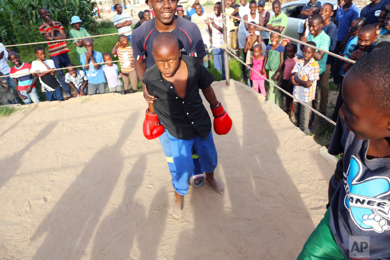 In this Feb. 12, 2017 photo, a young boy is restrained by a referee during a boxing match in Chitungwiza about 30 kilometres south east of Harare. (AP Photo/Tsvangirayi Mukwazhi)