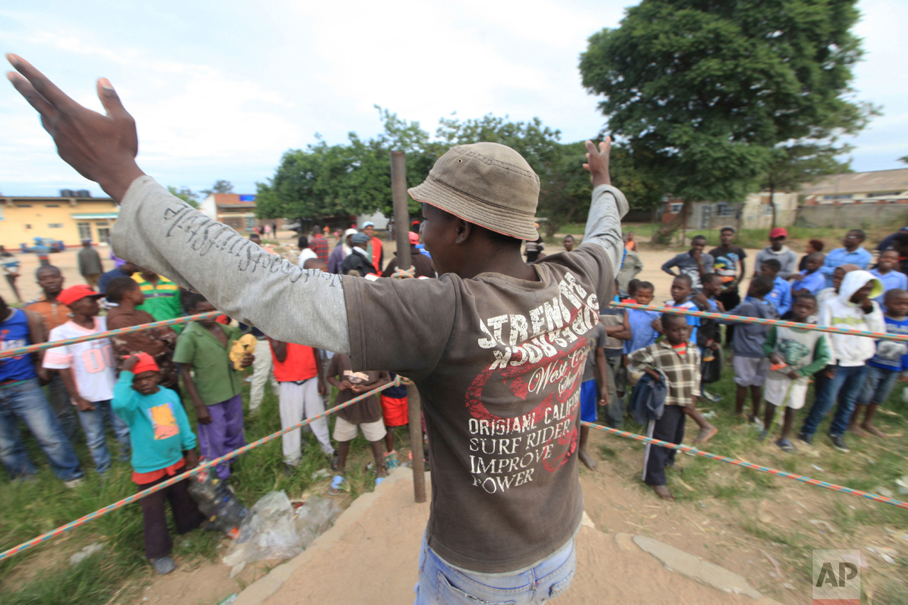 In this Sunday, March 11, 2017 photo, a referee invites young boys into the boxing ring in Chitungwiza, Zimbabwe. (AP Photo/Tsvangirayi Mukwazhi)
