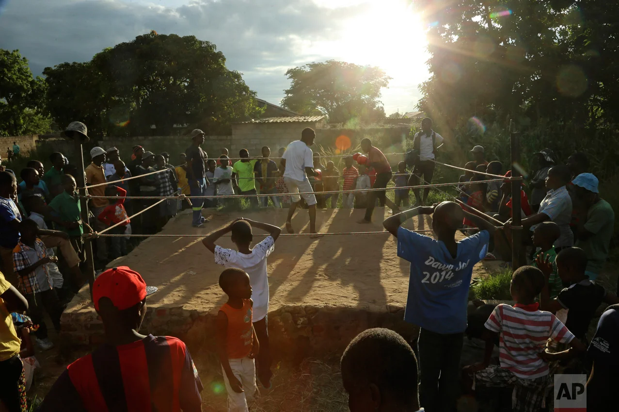 In this Saturday, Feb. 12, 2017 photo, young boys fight in a boxing ring in Chitungwiza, Zimbabwe. Zimbabwean boys as young as 10 hurry every weekend to a boxing ring whose nickname, Wafa Wafa, in the local Shona language suggests that whoever enters will be lucky to come out alive. (AP Photo/Tsvangirayi Mukwazhi)
