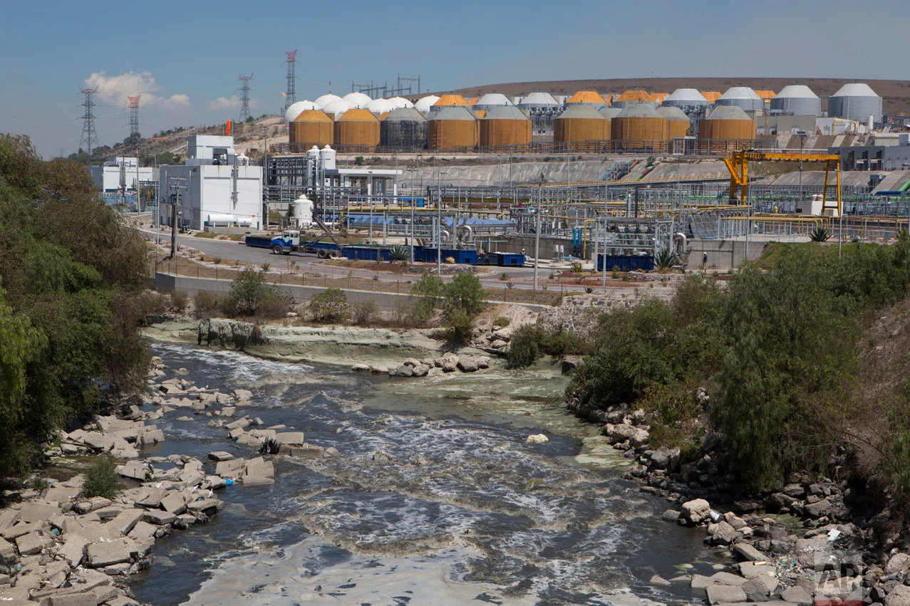 In this March 17, 2017 photo, a river of untreated sewage flows past the $530 million wastewater treatment plant in Atotonilco de Tula, Hidalgo state, Mexico. After years of delays, the plant, billed as the largest of its kind in Latin America, is in its testing phase and expected to come online later this year. (AP Photo/Rebecca Blackwell)