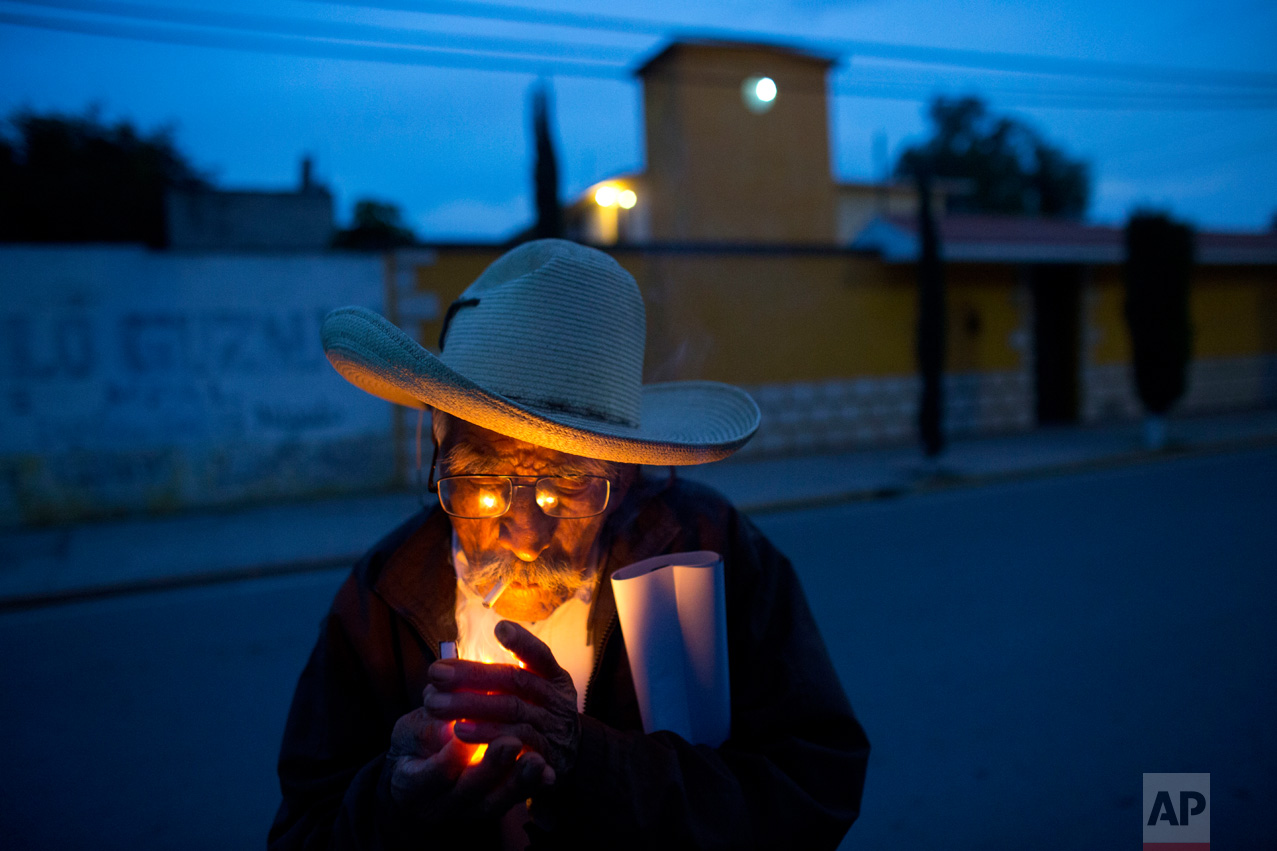 In this March 31, 2017 photo, farmer Manuel Ortega, 89, lights a cigarette following a strategy meeting by farmers in Tepatepec, Hidalgo state, Mexico. Ortega, who still works in the fields and gets around town by bicycle, said he was raised on the leafy greens, beans and zucchini grown here. "It never gave me the runs," he added with a laugh. (AP Photo/Rebecca Blackwell)