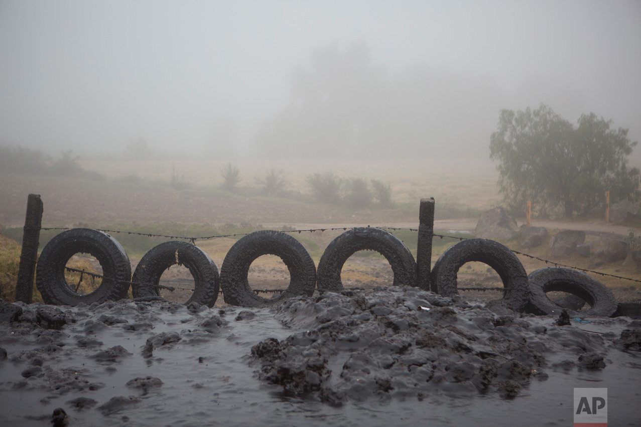 In this March 17, 2017 photo, tires protect a field from a thick layer of mud ejected from an adjacent irrigation canal when high flow creates a 30-foot spray, near the Endho reservoir, Hidalgo state, Mexico. Today, a vast network of low-tech, gravity-based canals irrigates more than 90,000 hectares (220,000 acres) of the Mezquital Valley with wastewater. Communities in other Mexican states have followed Hidalgo's example, and begun using sewage for farm irrigation. (AP Photo/Rebecca Blackwell)