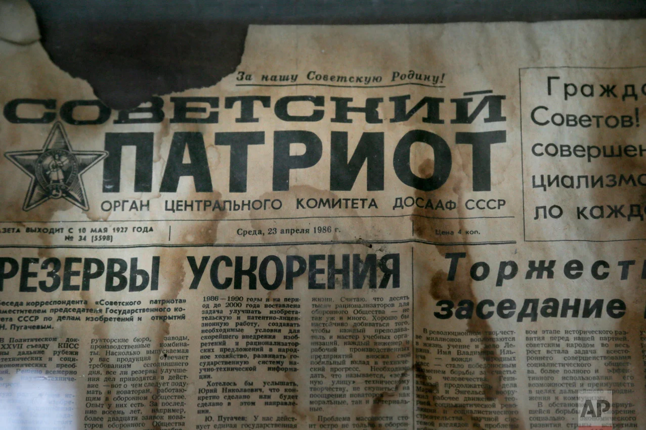 In this photo taken Wednesday, April 5, 2017, an edition of the newspaper Sovetsky Patriot, dated three days before the nuclear explosion, is attached to a bulletin board in a house of culture in the deserted town of Pripyat, some 3 kilometers (1.86 miles) from the Chernobyl nuclear power plant Ukraine. (AP Photo/Efrem Lukatsky)