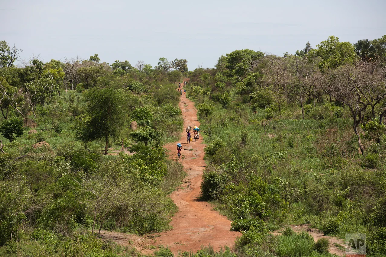 In this Wednesday March 29, 2017 photo, South Sudanese refugees walk towards the Ugandan border at Busia. There were high hopes that South Sudan would have peace and stability after its independence from neighboring Sudan in 2011. But the country plunged into ethnic violence in December 2013 when forces loyal to President Salva Kiir, a Dinka, started battling those loyal to Riek Machar, his former vice president who is a Nuer. (AP Photo/Jerome Delay)