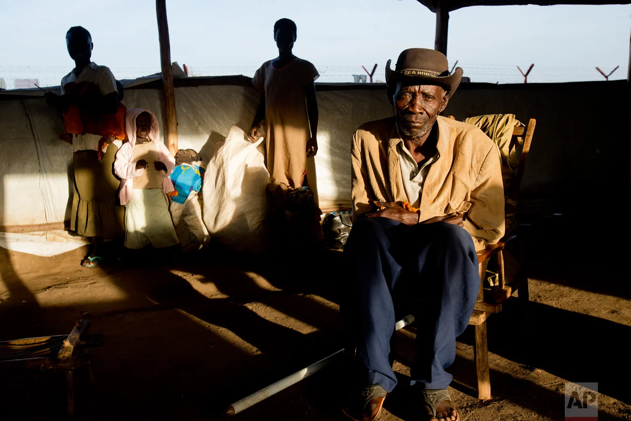 In this Friday March 31, 2017 photo, Alfred Wani sits in a communal tent at the Kuluba, Uganda, transit camp, waiting for transport to Imvepi camp. Alfred is one of more than 800,000 South Sudanese who have fled to Uganda just since July. (AP Photo/Jerome Delay)