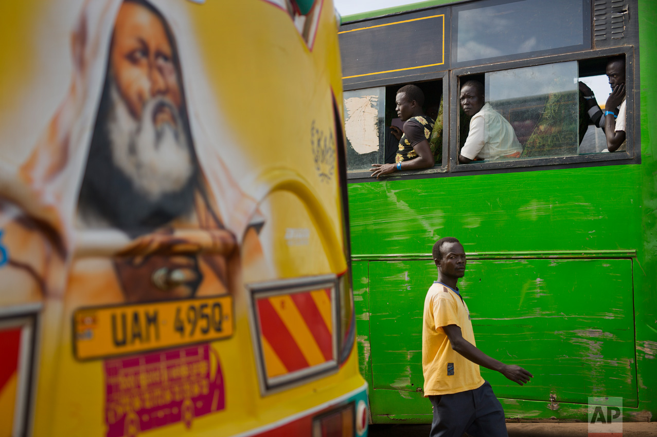 In this Friday March 31, 2017 photo, South Sudanese refugees board buses at the Kuluba transit camp in Uganda. Over 1000 refugees transit daily through Kuluba and are then transported to Imvepi for permanent settlement. (AP Photo/Jerome Delay)