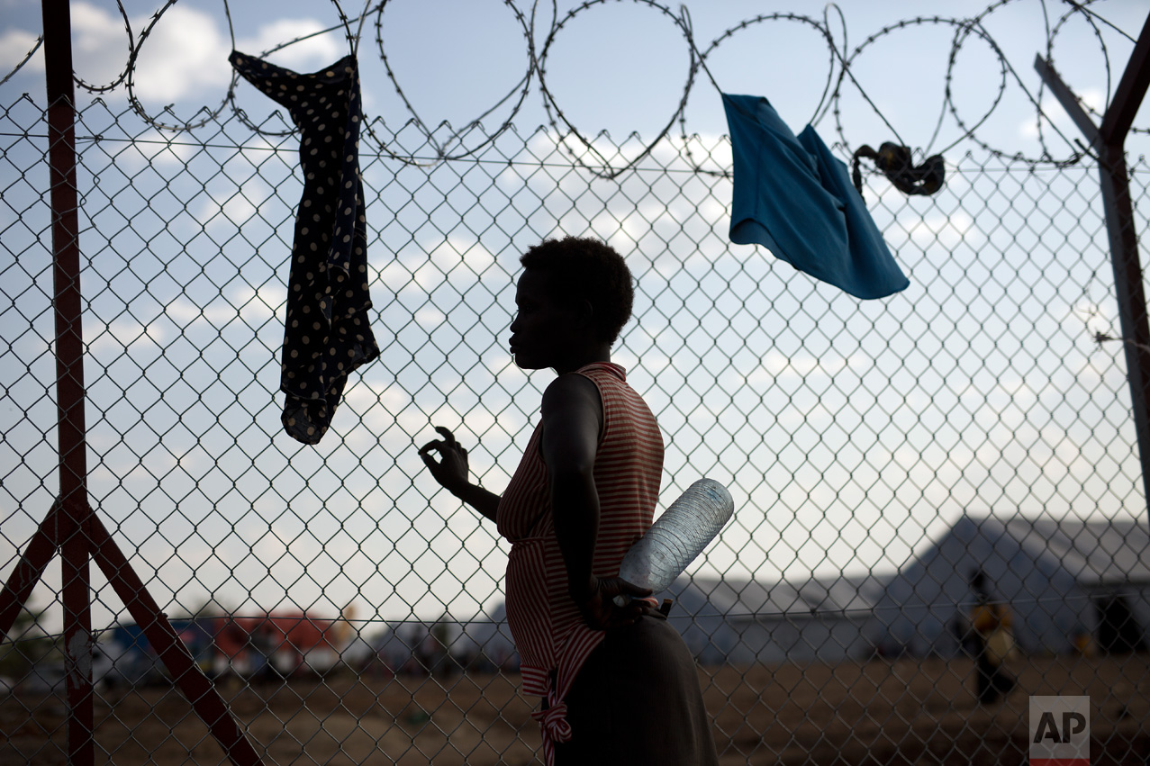 In this Saturday, April 1, 2017 photo, Ide Djen, 29, a South Sudanese refugee from Kenienba, holds an empty bottle of water as she waits by water pumps in the Imvepi refugee settlement in northern Uganda. (AP Photo/Jerome Delay)