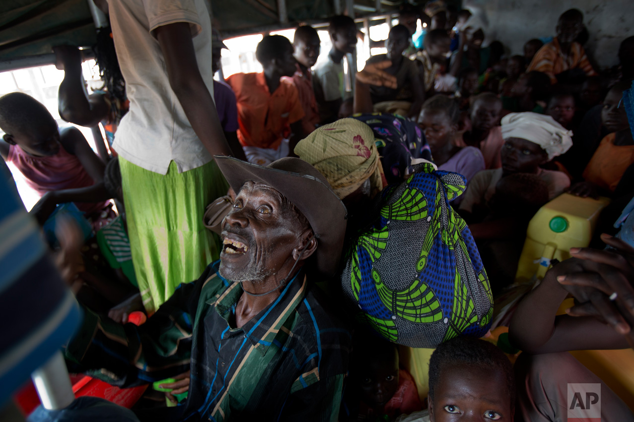 In this Tuesday, April 4, 2017 photo in the Imvepi camp, Alfred Wani and his family travel in trucks to the plots of land they were allocated by the Ugandan government for their resettlement. (AP Photo/Jerome Delay)