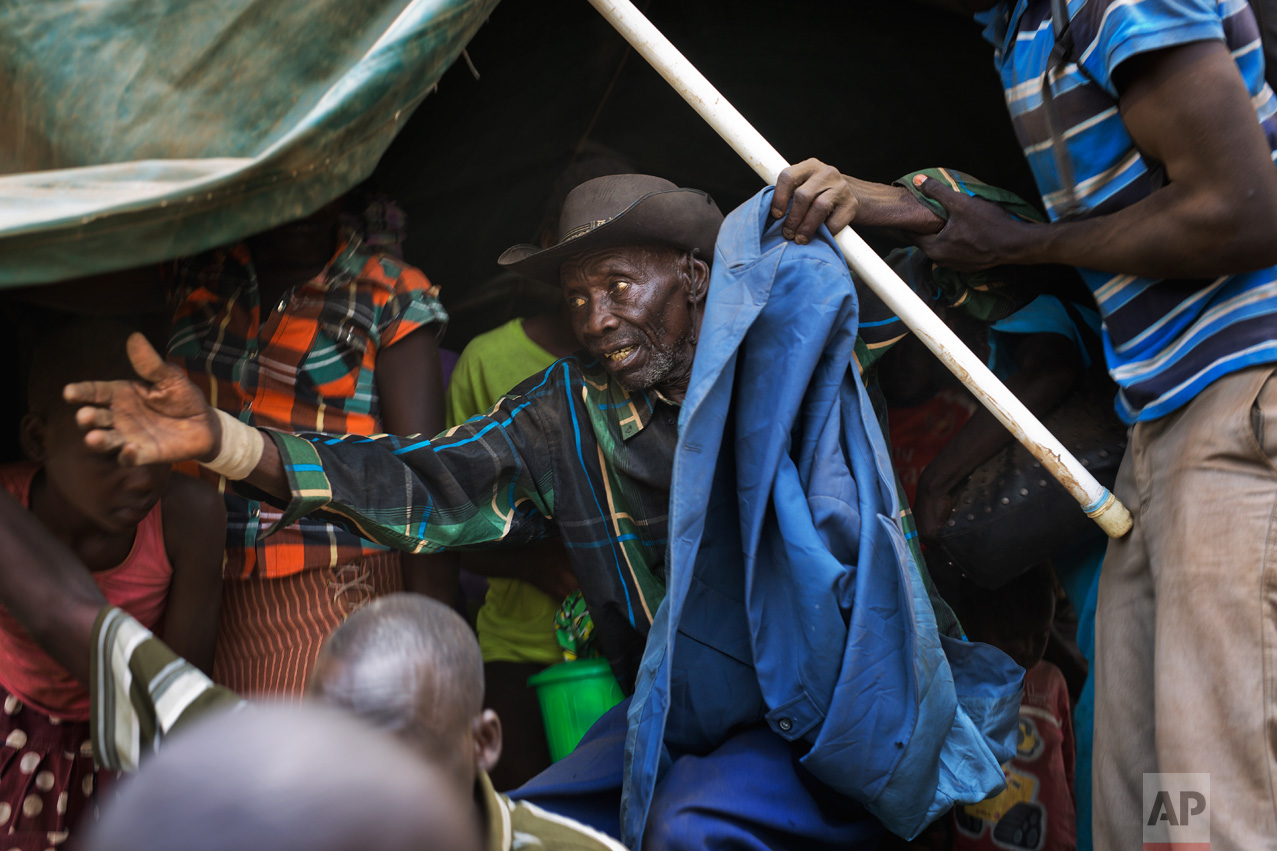 In this Tuesday, April 4, 2017 photo in the Imvepi camp, Alfred Wani disembarks from a truck that took him and family to the plots of land they were allocated by the Ugandan government for their resettlement. (AP Photo/Jerome Delay)