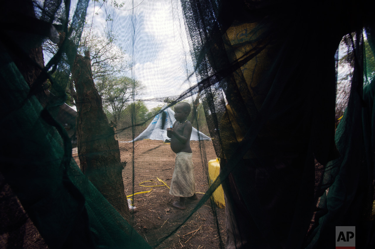 In this Friday, April 7, 2017 photo in the Imvepi camp, Tito walks on the plot of land he and family were allocated by the Ugandan government for their resettlement. (AP Photo/Jerome Delay)