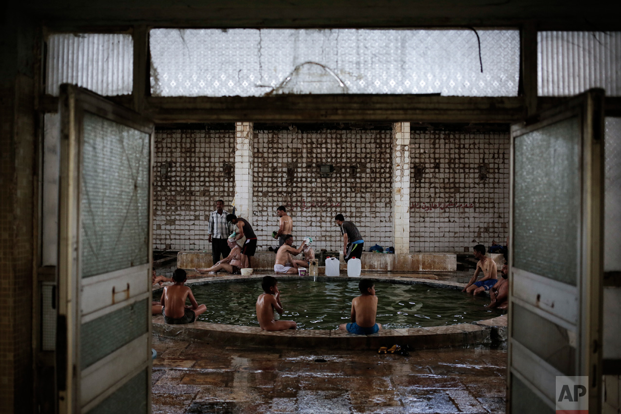 Customers enjoy the Hamam Alil sulphur spa, situated in an historic building half an hour south of Mosul, Thursday, April 27, 2017. Before the Islamic State took over the town of Hamam Alil in 2014, people from all over Iraq visited the historic spa. (AP Photo/Bram Janssen)