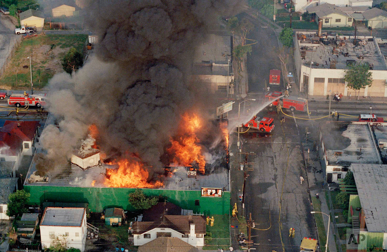 In this April 30, 1992 photo, a fire burns out of control at the corner of 67th Street and West Boulevard in South Central Los Angeles. On April 29, 1992, four white police officers were declared innocent in the beating of black motorist Rodney King, and Los Angeles erupted in deadly riots. Three days later, 55 people were dead and more than 2,000 injured. Fires and looting had destroyed $1 billion worth of property. (AP Photo/Paul Sakuma)