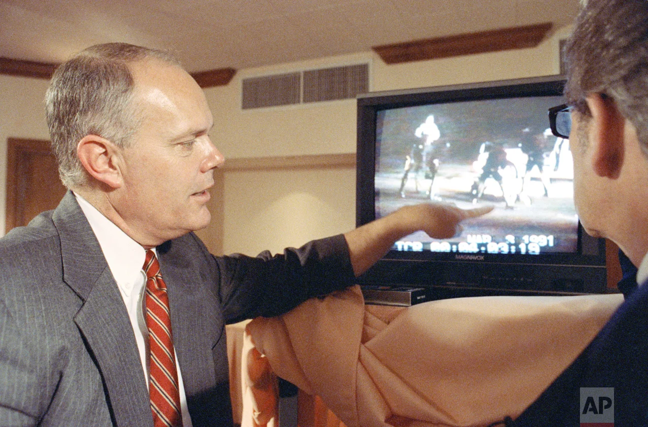 In this Saturday, April 18, 1993 photo, Los Angeles police officer Stacey Koon describes what is happening on the Rodney King beating video to host Steve Dunleavy at a hotel in Valencia, Calif., during the taping of the syndicated television show "A Current Affair." Koon was interviewed shortly after he was found guilty in the Rodney King civil rights trial. (AP Photo/Douglas C. Pizac)