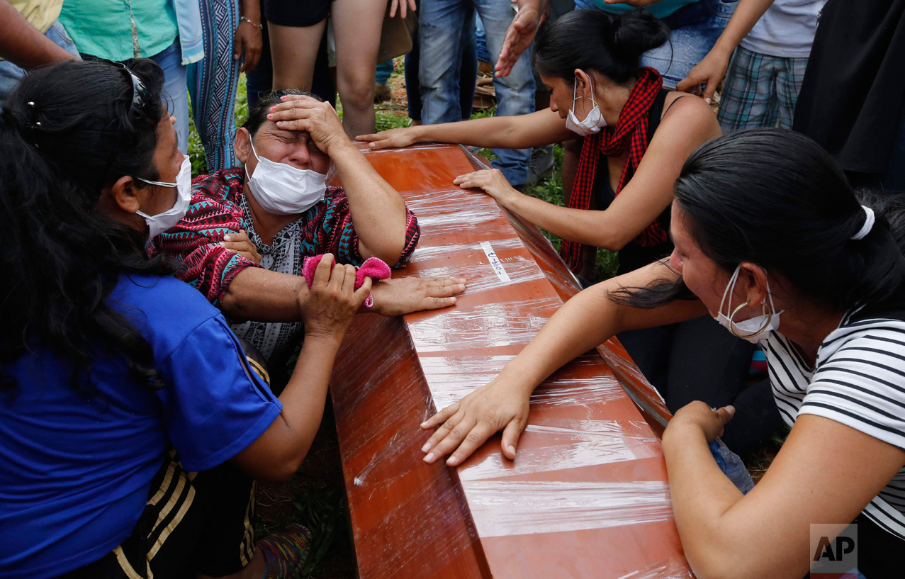 Women cry over the coffin of a relative, a victim of a deadly avalanche due to heavy rains, during a mass burial in Mocoa, Colombia, Monday, April 3, 2017. The grim search continues for the missing in southern Colombia after surging rivers sent an avalanche of floodwaters, mud and debris through the small city, killing more than 260 people and leaving many more injured and homeless. (AP Photo/Fernando Vergara)