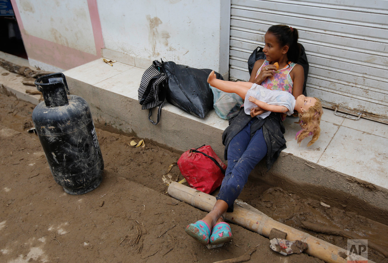 A girl holds a doll rescued from her damaged house in Mocoa, Colombia, Sunday, April 2, 2017. A grim search for the missing resumed at dawn Sunday in southern Colombia after surging rivers sent an avalanche of floodwaters, mud and debris through a city, killing at least 200 people and leaving many more injured and homeless. (AP Photo/Fernando Vergara)