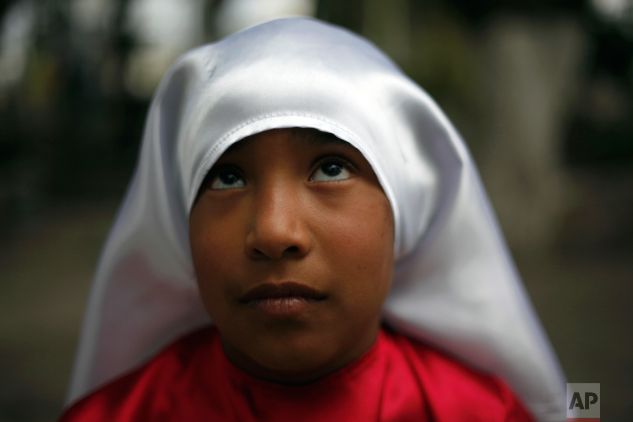 A girl dressed to participate in a reenactment of the Via Crucis, or Way of the Cross, waits for a practice in the village of San Mateo, some 50 km north of Mexico City, Mexico, Thursday April 13, 2017. Holy Week commemorates the last week of the earthly life of Jesus Christ culminating in his crucifixion on Good Friday and his resurrection on Easter Sunday. (AP Photo/Marco Ugarte)