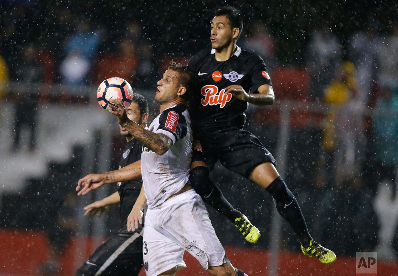 Rafael Moura, left, of Brazil's Atletico Mineiro fights for the ball with Luis Cardozo of Paraguay's Libertad during a Copa Libertadores soccer match in Asuncion, Paraguay, Wednesday, April 19, 2017.(AP Photo/Jorge Saenz)