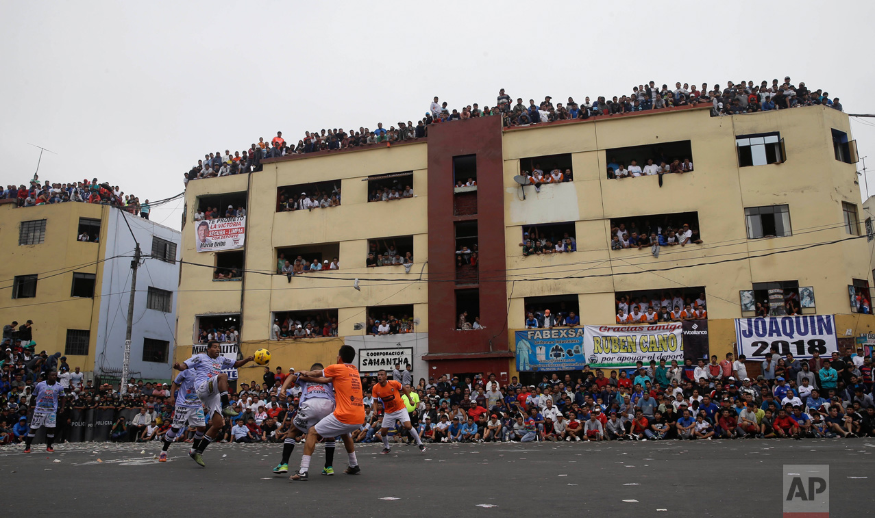  In this Monday, May 1, 2017 photo, residents crowd the balconies of an apartment building to watch soccer teams "La Polvora," (Gun Powder) and "Los Chatarreros" (The Scrappers) play a semi-final game at the Little World Cup Porvenir street soccer ch