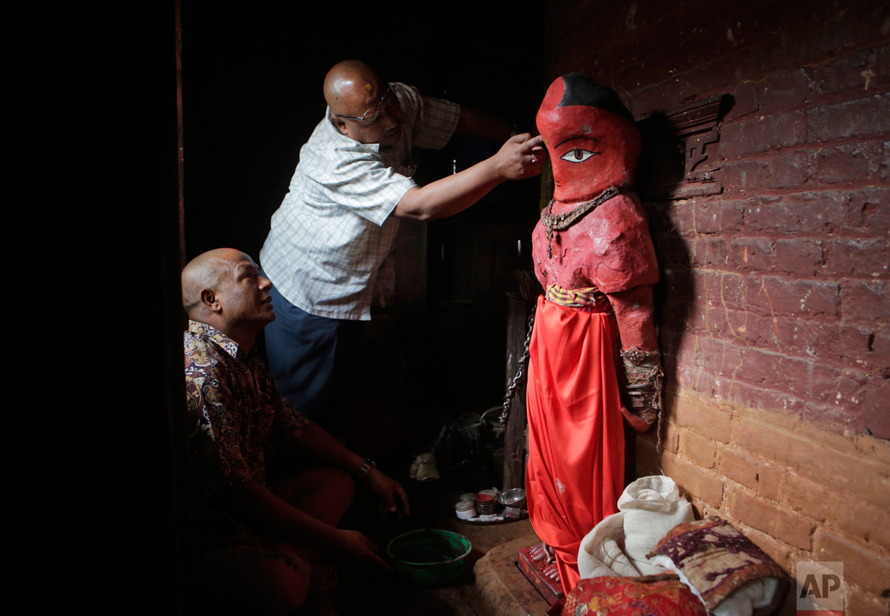  In this April 19, 2017, photo, Chitrakar artist Amir Nekhu helps repair the statue of Rato Machindranath in Machindra Bahal in Lalitpur, Nepal. The wide-eyed, red painted clay statue of Machindranath is kept locked away for months until it is to be 