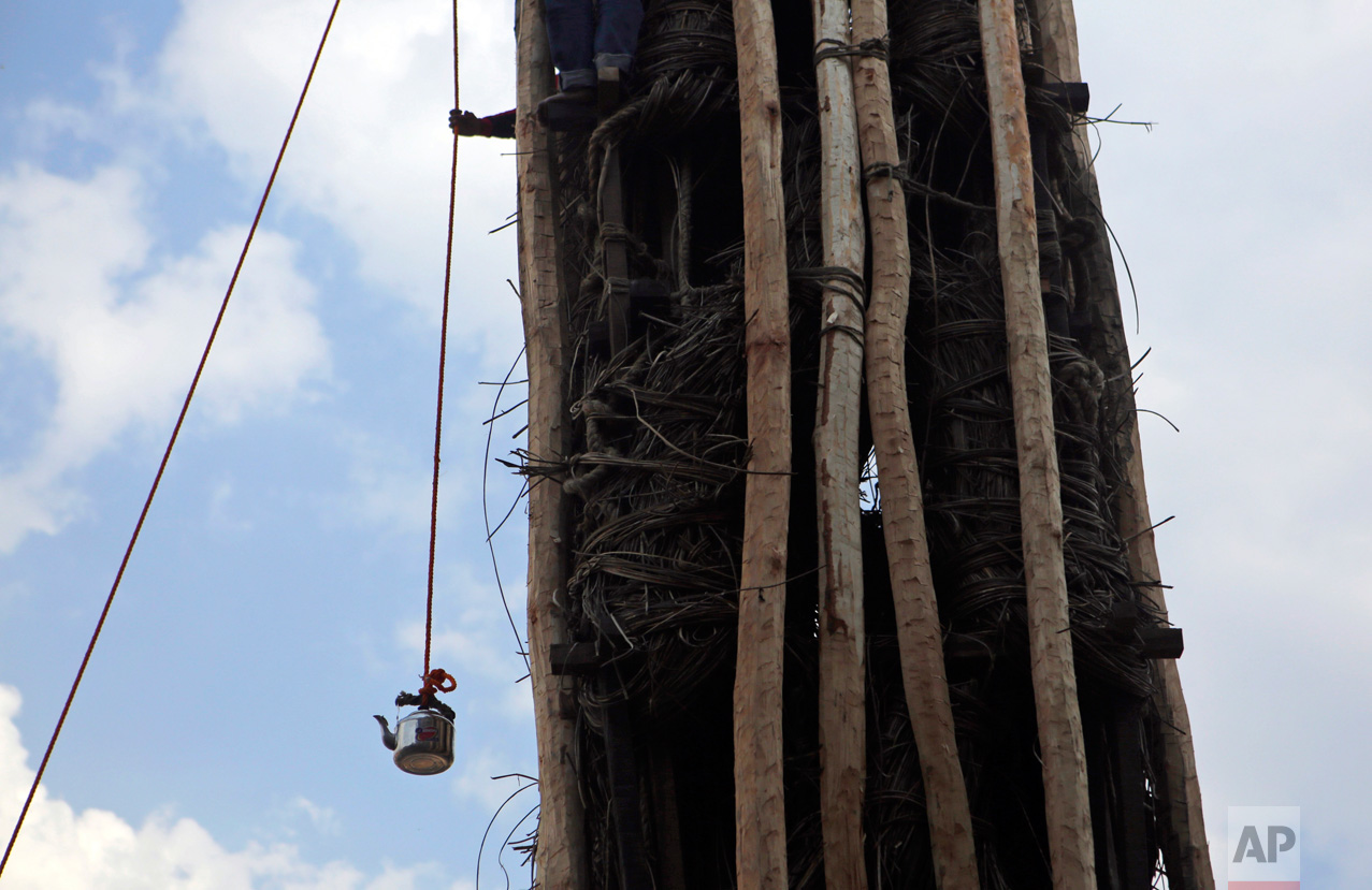  In this April 27, 2017, photo, a kettle of drinking water is hoisted up with a rope by a Barahi community member during the construction of the Rato Machindranath Chariot in Lalitpur, Nepal. The 15-meter (48-foot) tall wooden chariot is built to app