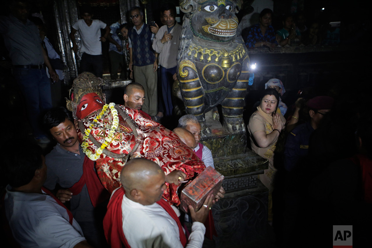  In this April 27, 2017, photo, Hindu priests carry the Rato machindranath deity to its seat inside a 15-meter (48-foot) tall wooden chariot to be taken around Patan city during an annual festival in Lalitpur, Nepal. Legend says that around the 7th c