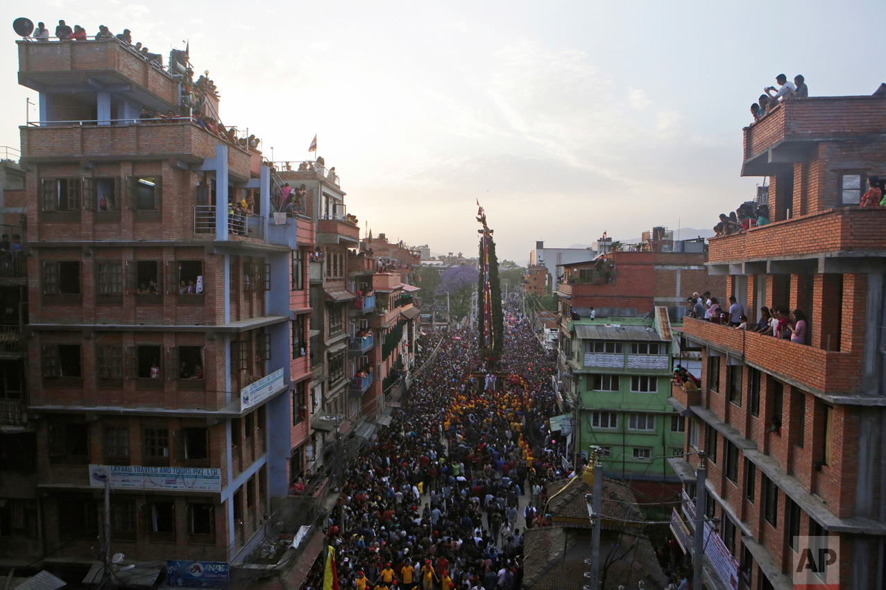  In this April 30, 2017, photo, devotees fill the streets in the Rato Machindranath Chariot festival in Lalitpur, Nepal. Lines of followers pull on two thick ropes to move the massive chariot along the narrow roads of Patan. With no steering or brake