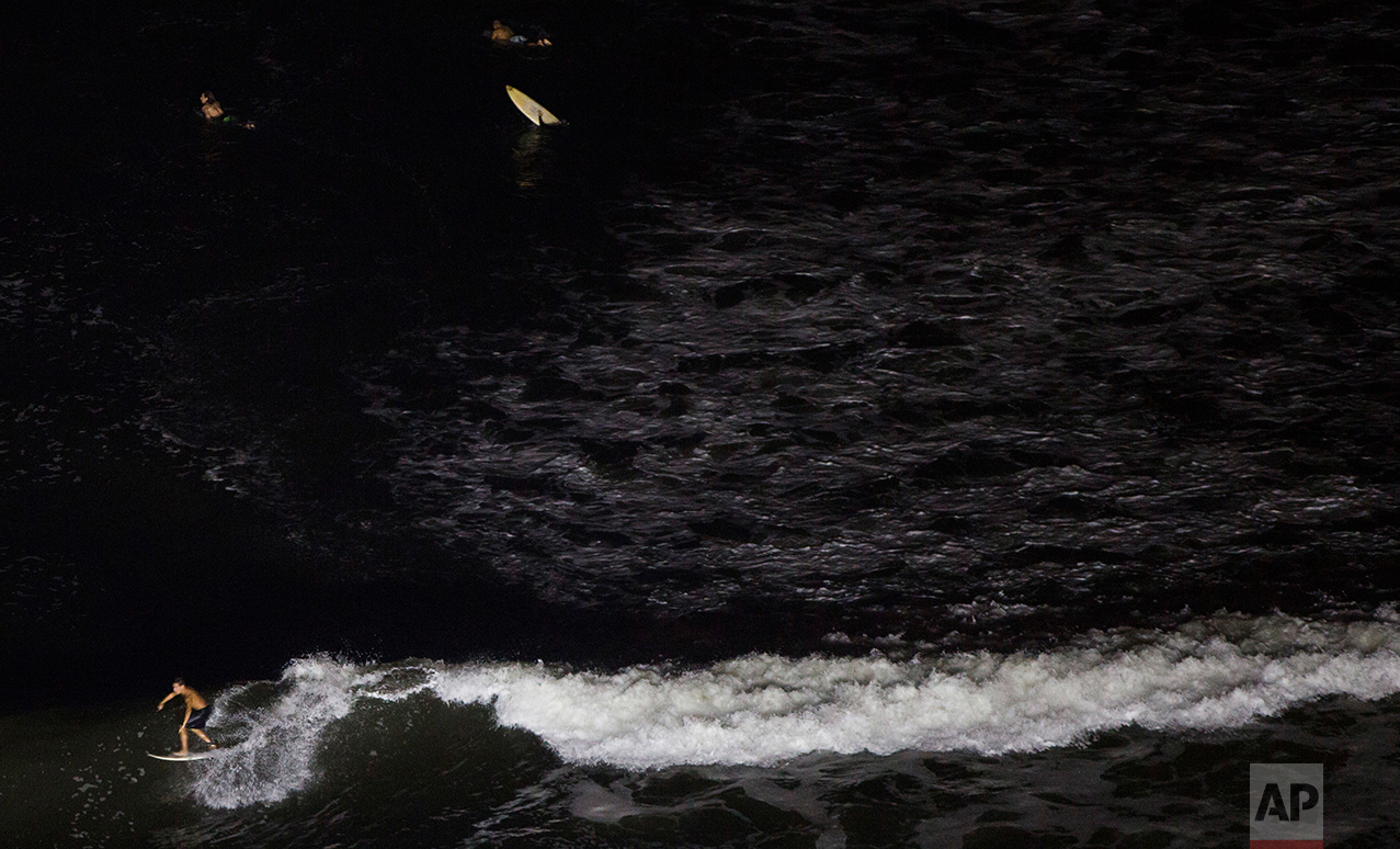  In this March 9, 2017 photo, a man surfs in the waters of La Pampilla beach in Lima, Peru. Pampilla is the second beach in Latin America that is set up for night surfing. (AP Photo/Rodrigo Abd) 