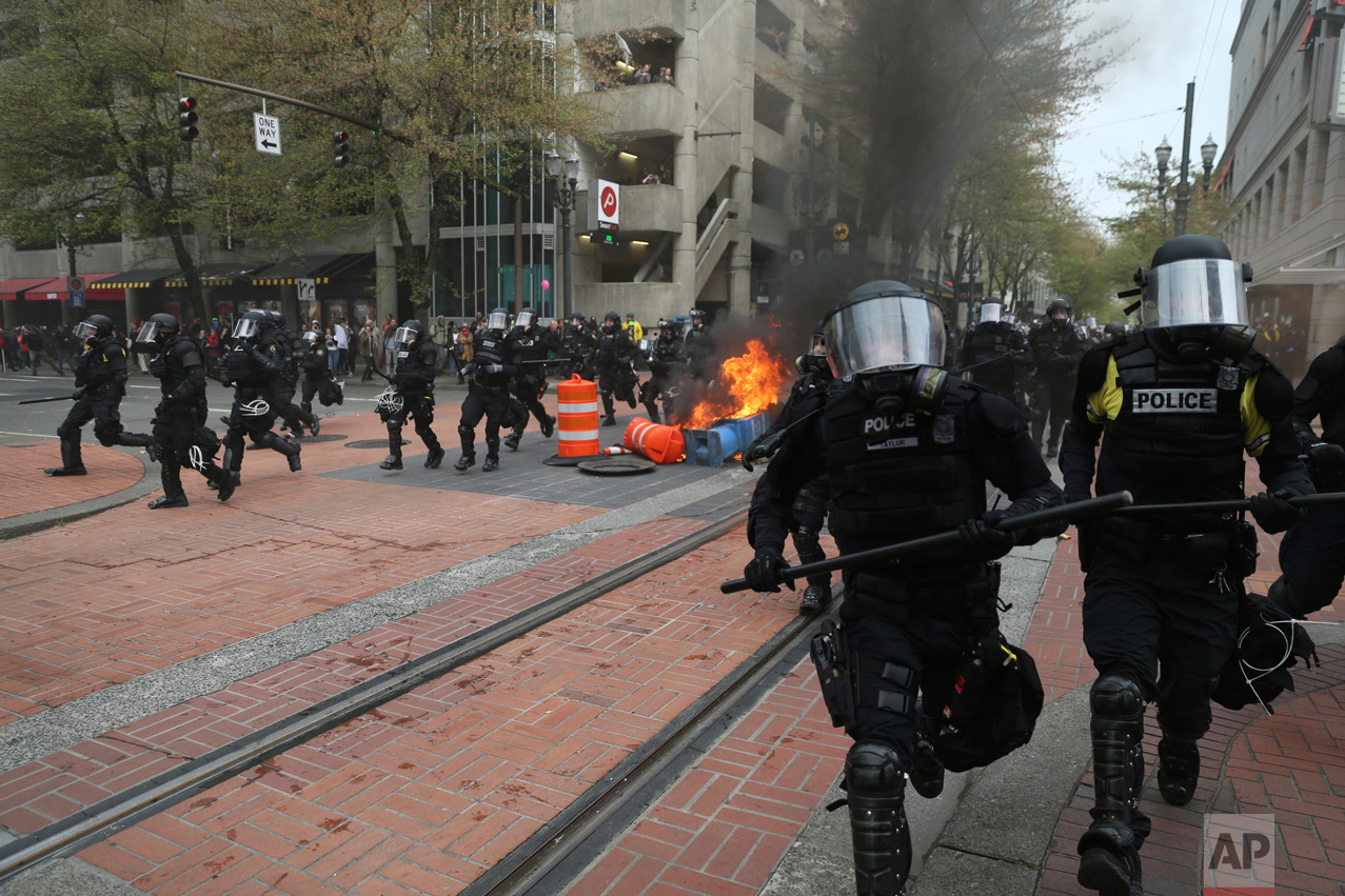  Police officers disperse people participating in a May Day rally in downtown Portland, Ore., Monday, May 1, 2017. Over 100 police officers clad in body armor and gas masks shut down a march they said had become a riot late Monday and arrested people