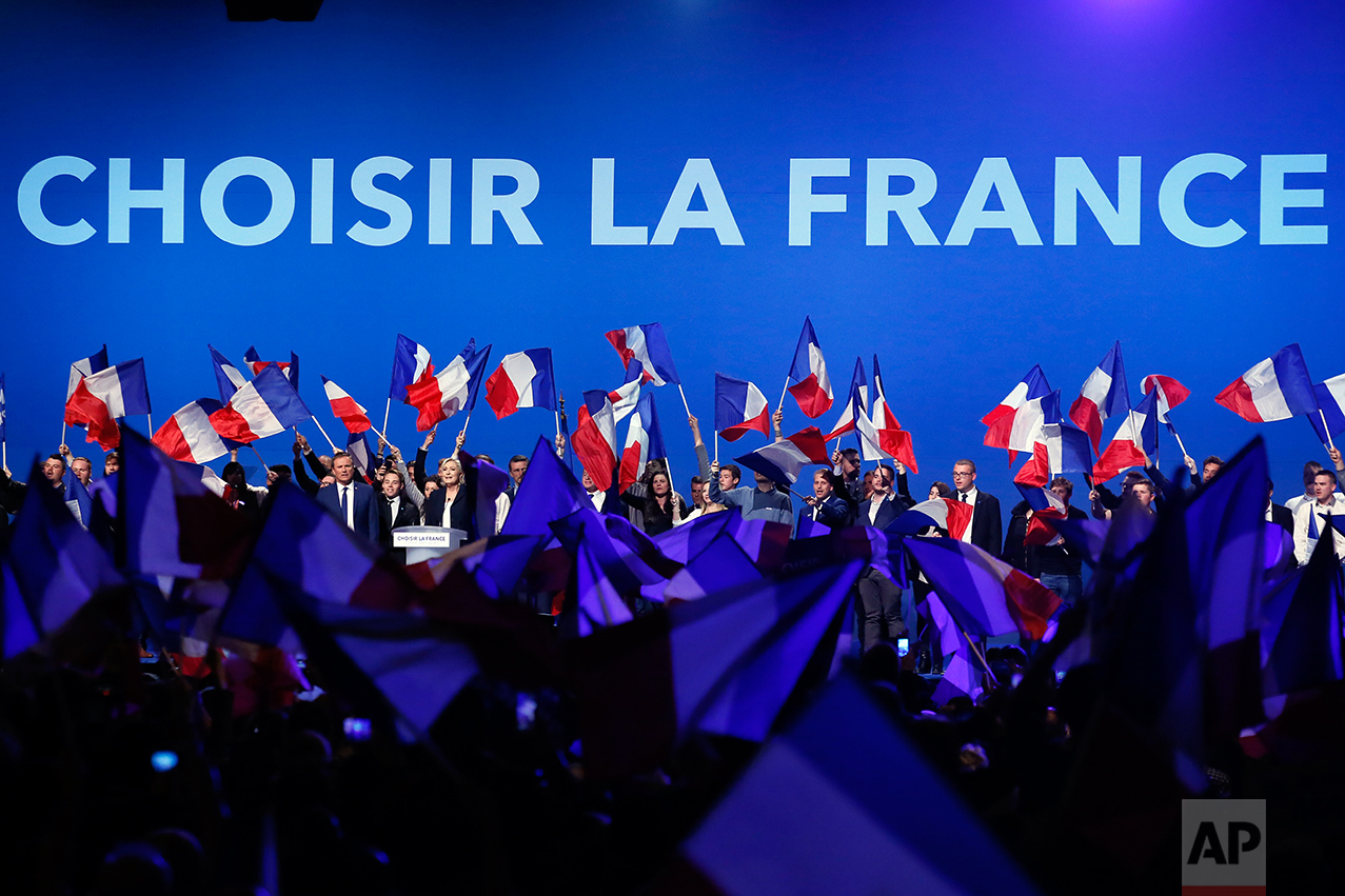 French conservative candidate from the first-round election Nicolas Dupont-Aignan, left, and french far-right presidential candidate Marine Le Pen cheer their supporters at the end of their meeting, Monday May 1, 2017, in Villepinte, outside Paris. 