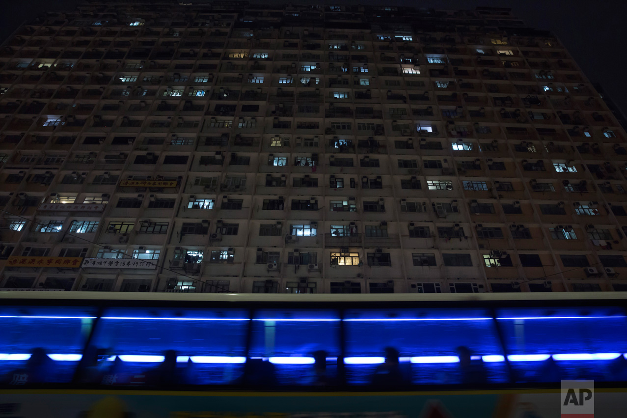  In this Tuesday, April 25, 2017 photo, a bus drives past a residential and commercial building where the "coffin homes" are located in Hong Kong. There’s a dark side to the property boom in wealthy Hong Kong, where hundreds of thousands of people pr