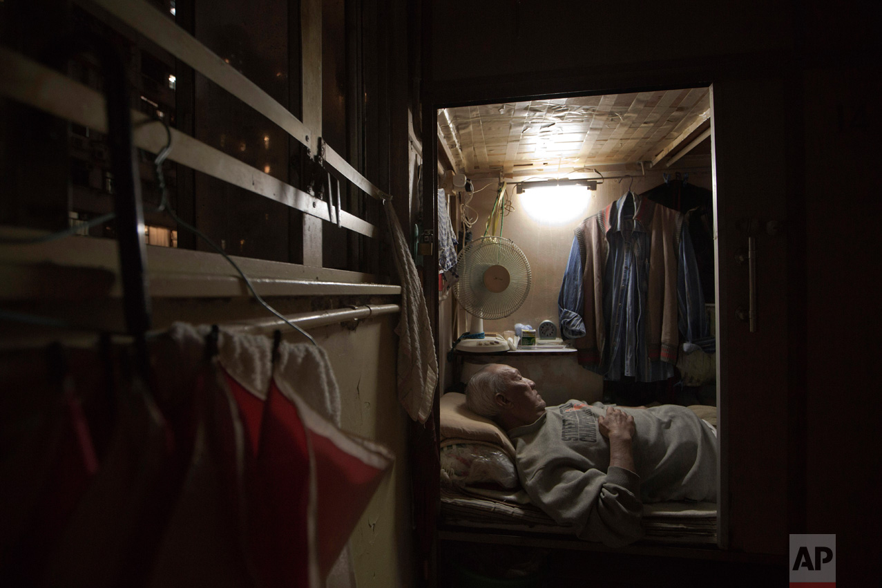 In this Thursday, March 28, 2017 photo, Tse Chu, a retired waiter, sleeps in his "coffin home" in Hong Kong. In wealthy Hong Kong, there's a dark side to a housing boom, with hundreds of thousands of people forced to live in partitioned shoebox apar