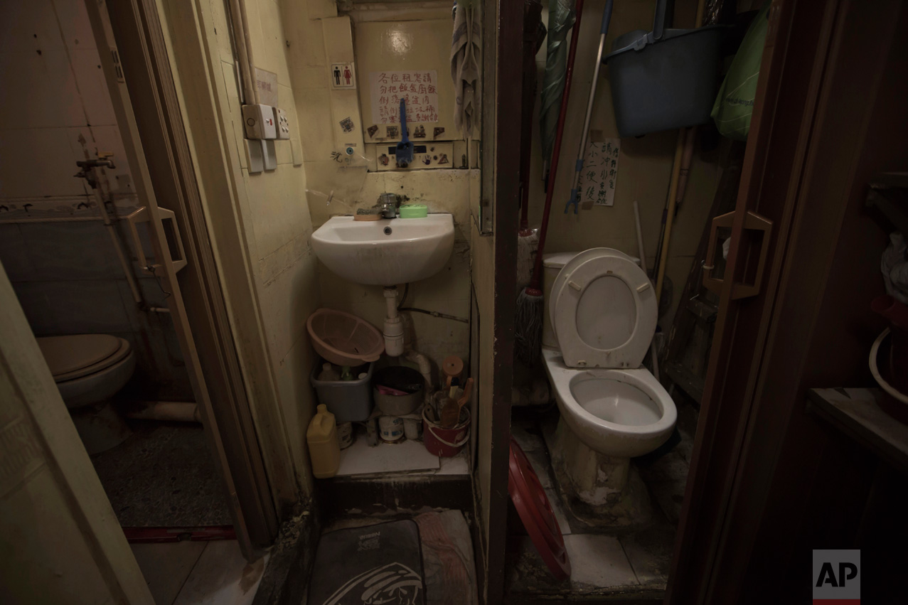  In this Thursday, March 28, 2017 photo, a set of grimy toilets and single sink shared by the coffin home's two dozen inhabitants, including a few single women, is located at a flat in Hong Kong. In wealthy Hong Kong, there's a dark side to a housing