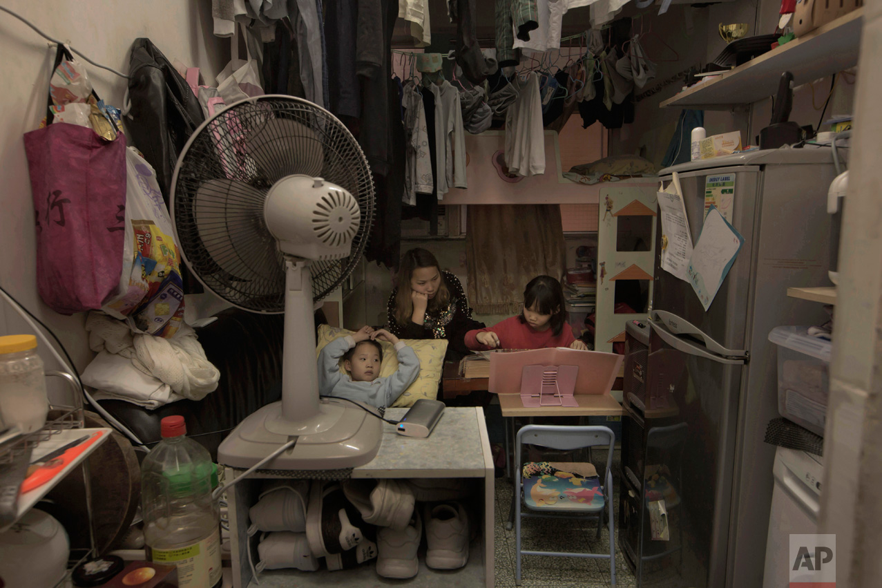  In this Friday, March 17, 2017 photo, Li Suet-wen and her son, 6, and daughter, 8, live in a 120-square foot room crammed with a bunk bed, small couch, fridge, washing machine and small table in an aging walkup in Hong Kong as she pays HK$4,500 ($58