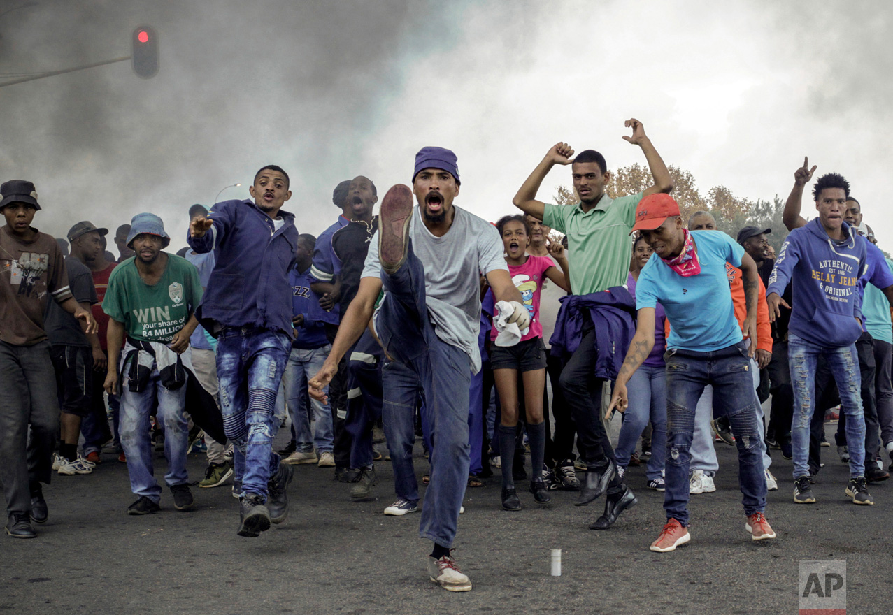 Protesters sing and chant in front of a burning barricade in the Ennerdale, Johannesburg township of South Africa on Tuesday, May 9, 2017. Violent protests have erupted in South Africa's biggest city for a second day as protesters demand housing and other government services. (AP Photo)