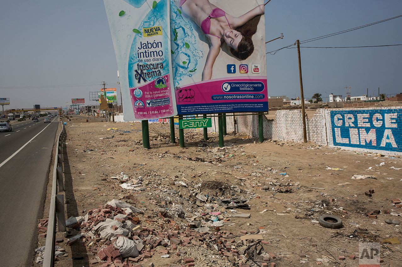  In this May 5, 2017 photo, a billboard advertising a soap brand stands among trash strewn along the Pan American Highway on the south side of Lima, Peru. Wilfredo Ardito, a law professor from the Pontifical Catholic University of Peru who has studie