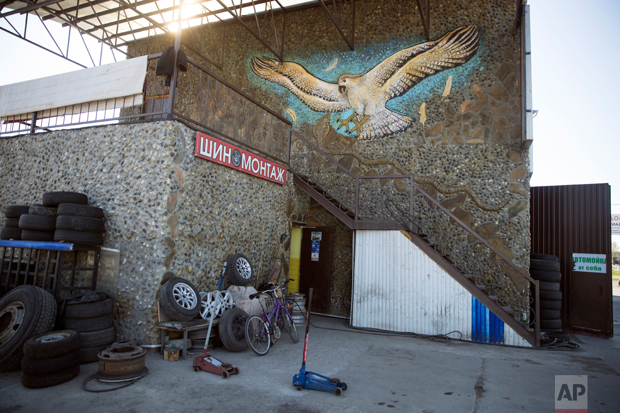  In this photo taken on Wednesday, May 3, 2017, an eagle sculpted and painted by Korshunov is seen above the tire service and restaurant next to a road in Shatura, about 125 kilometers (77,67 miles) east of Moscow, Russia. The playground slide in the