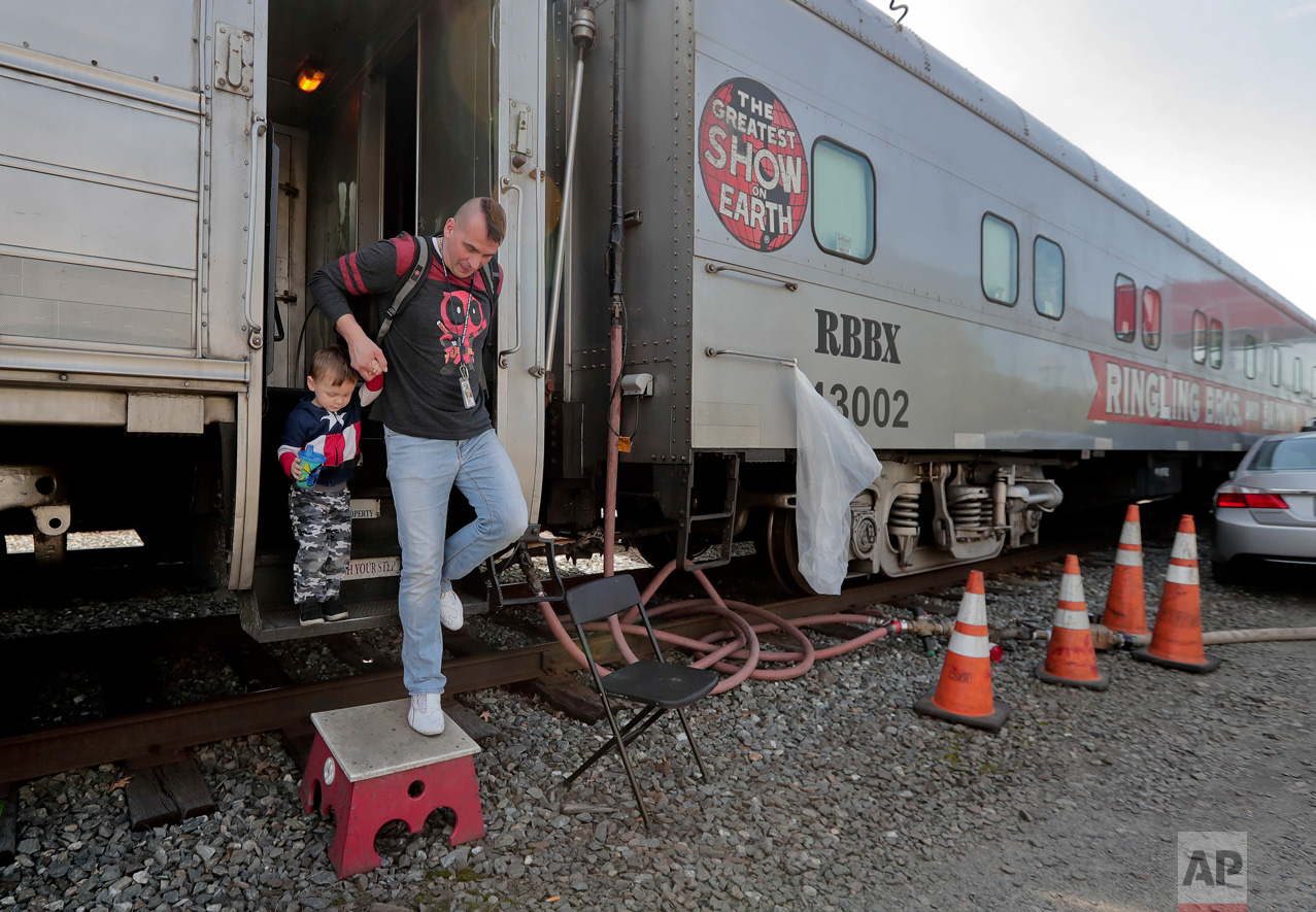  Boss clown Sandor Eke helps his 2-year-old son. Michael Eke step off the Ringling Bros. circus red unit's traveling train parked in a rail yard as they head to the arena for a show, Thursday, May 4, 2017, in Providence, R.I. Someday, he plans to tea
