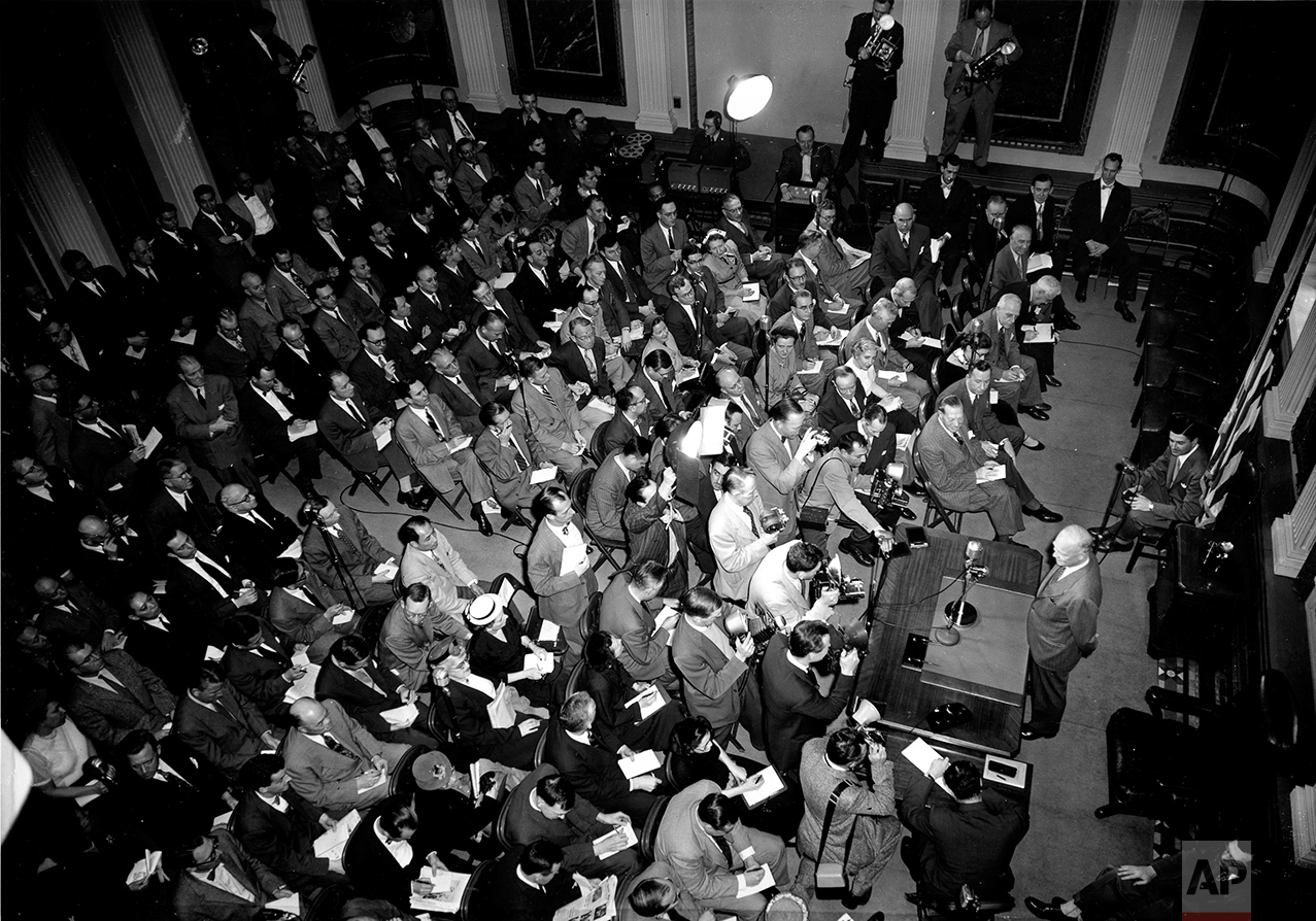  This aerial photo shows U.S. President Dwight D. Eisenhower standing behind a desk as he faces reporters and photographers at a news conference in the auditorium of the Executive Offices Building, across the street from the White House, in Washingto