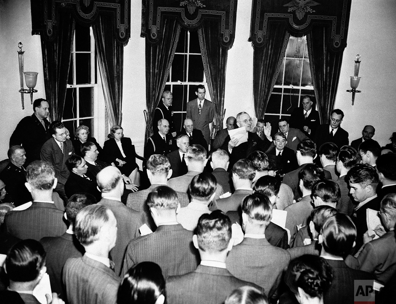  President Harry S. Truman (right center), gestures as he tells newsmen details of surrender of Germany during press conference at the White House in Washington, May 8, 1945 attended by 123 reporters. (AP Photo) 