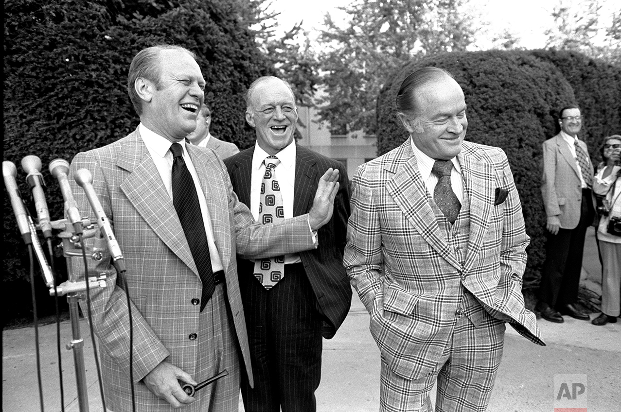  President Gerald Ford laughs at a joke from Bob Hope about their golf game Saturday evening, October 5, 1974, as they talked with newsmen outside Bethesda Naval Hospital prior to visiting First Lady Betty Ford.  Standing in the background is Hugh Da