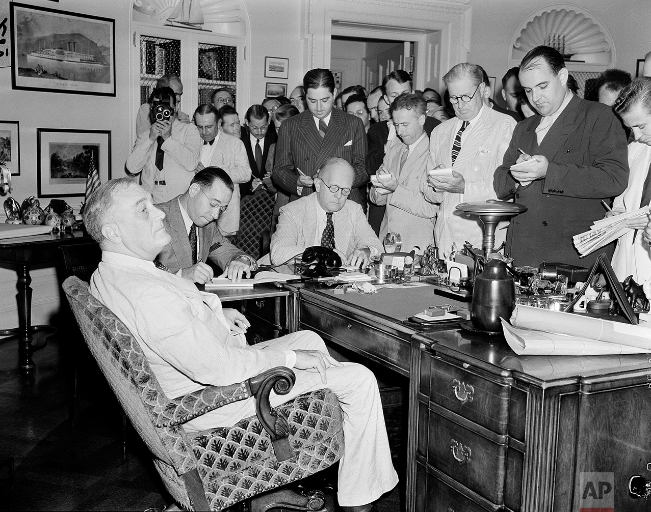  White House reporters, straining to hear every word, crowd around the desk of President Franklin D. Roosevelt in the executive office in Washington, D.C., Aug. 25, 1939, to hear the president say that he did not regard the present European situation