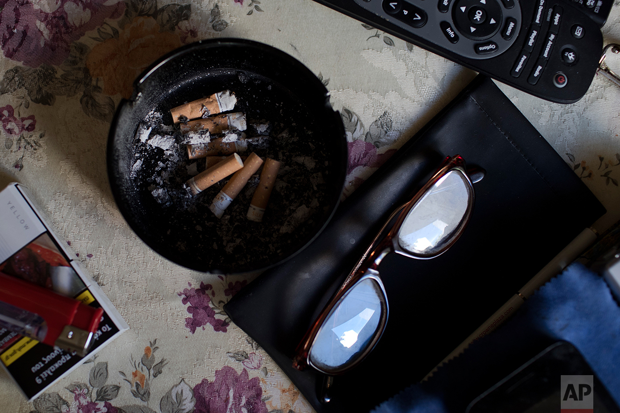  In this Monday, May 15, 2017 photo, an ashtray, a pair of glasses and a TV remote control sit on a table in the small apartment of Greek pensioner Fotis Milas, 66, a former paper factory employee in Athens. The new austerity measures are likely to c